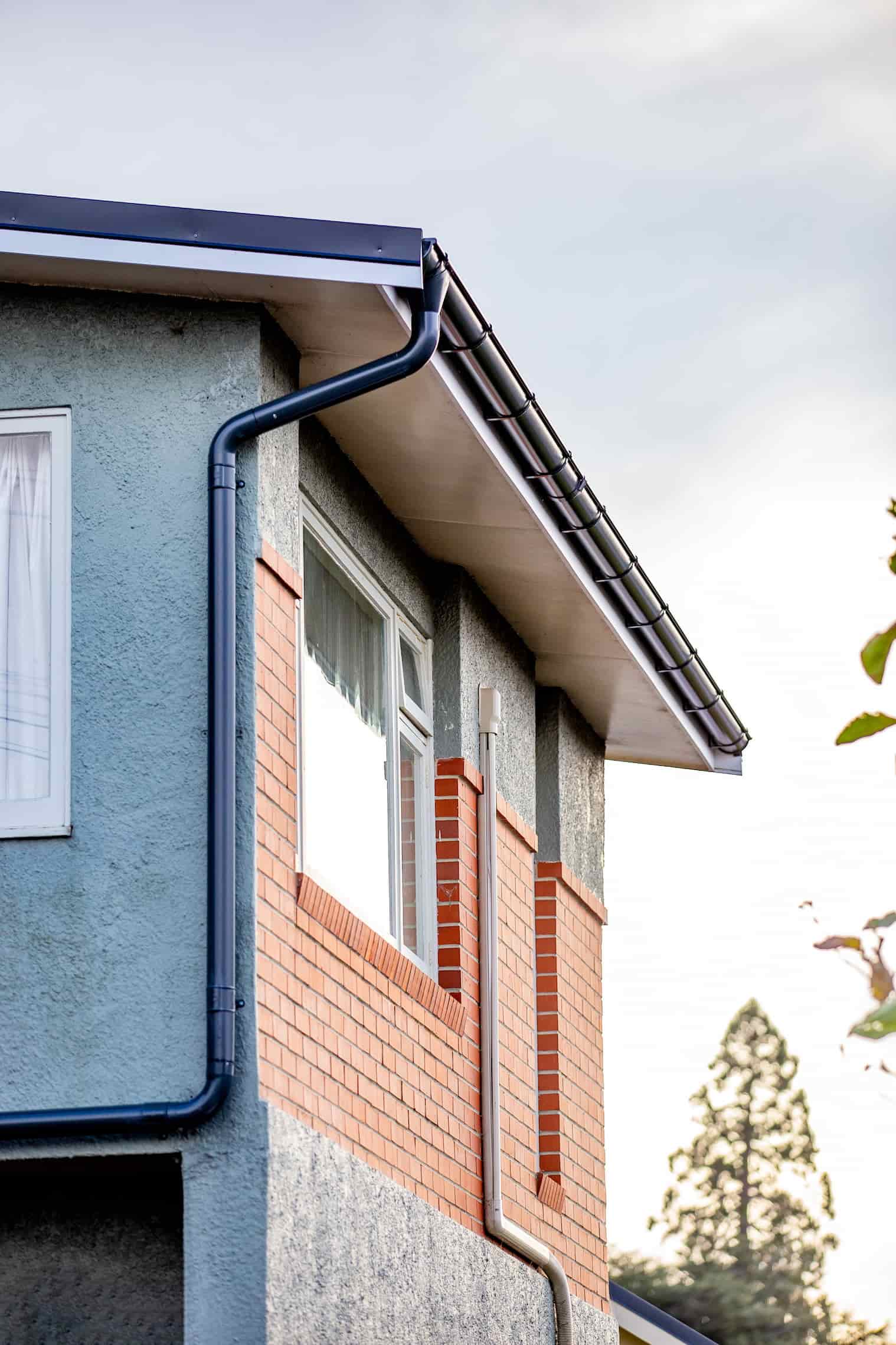 A clean half-round gutter installation detail with dark roof edging.