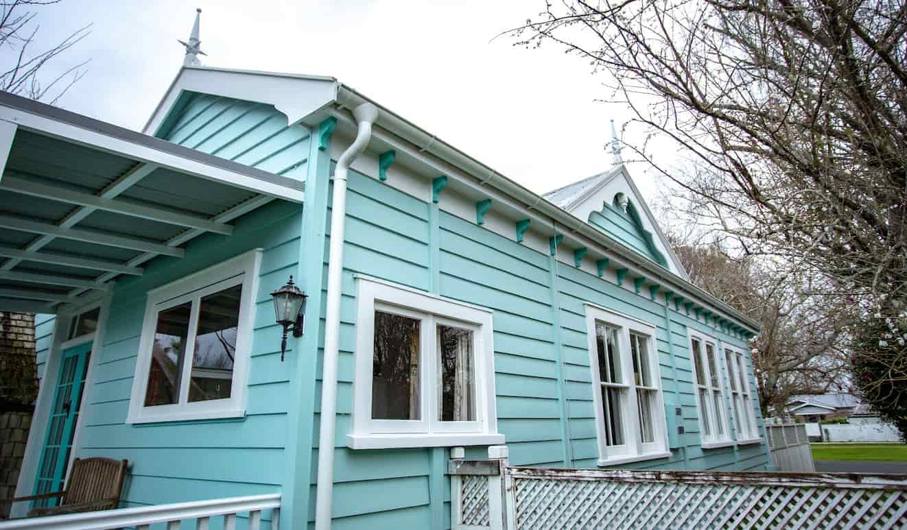 A blue house with white trim, standing out against the surroundings.