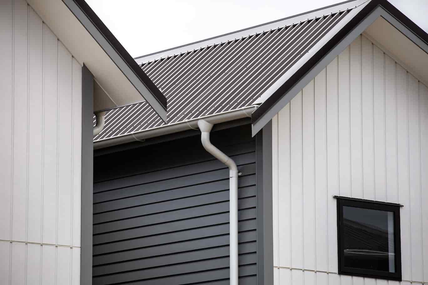 A close-up of two houses with metal roofs, showcasing their unique architectural design and durability.