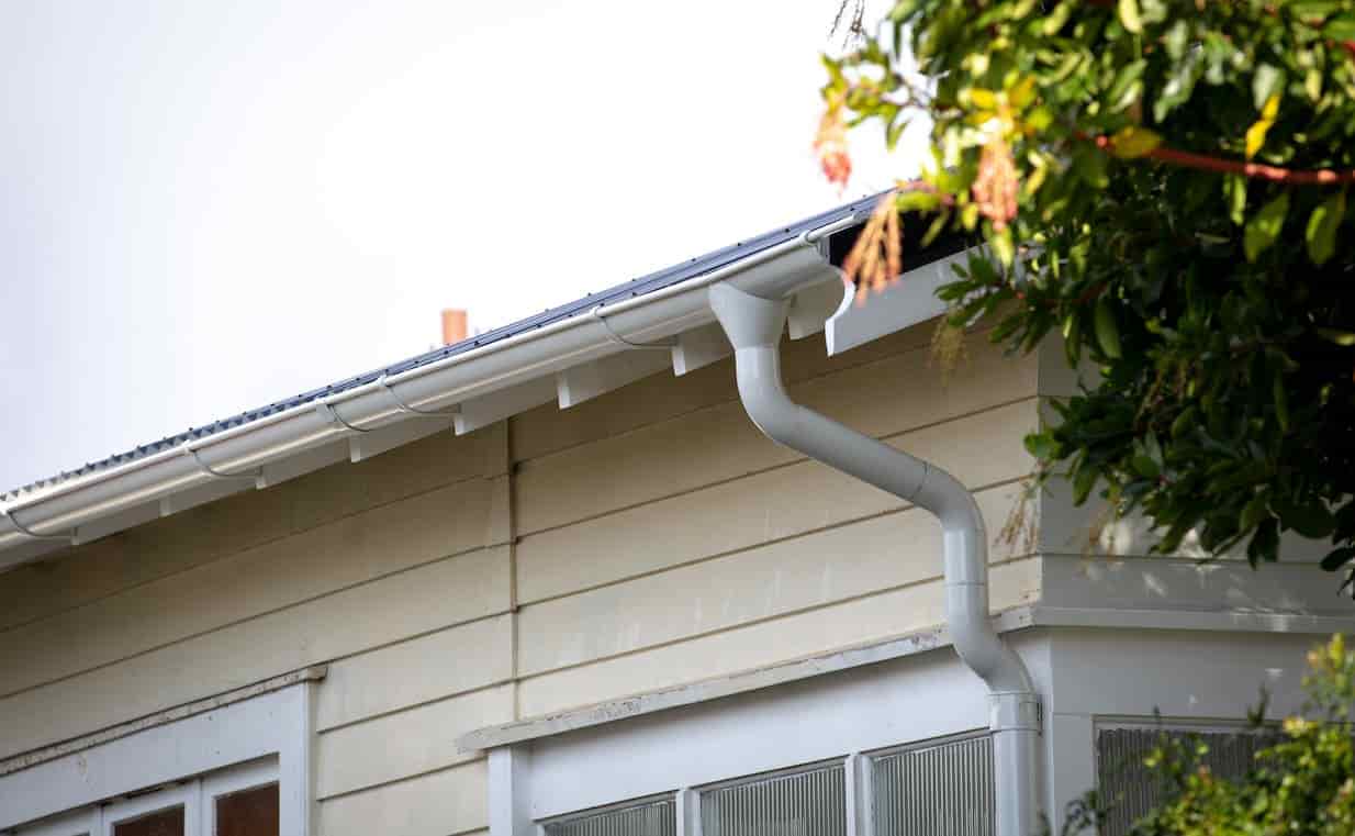 A white house with a Lindab gutter on the side.
