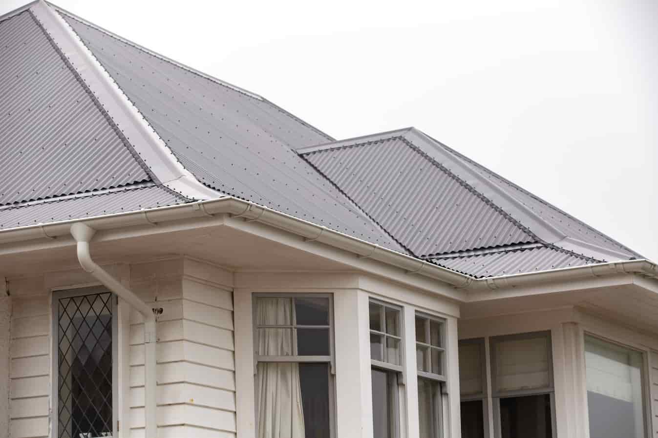 A white house with a roof, and with Lindab guttering. standing tall and elegant.