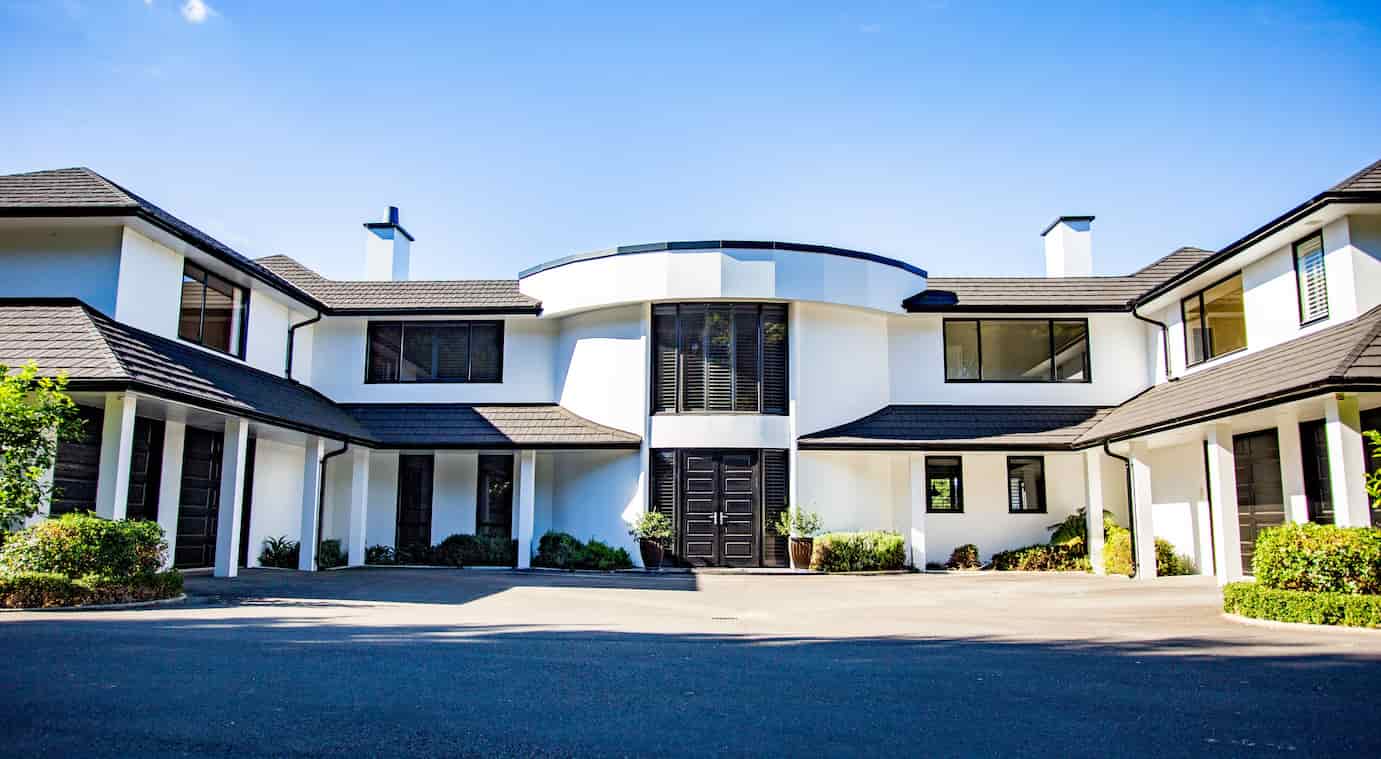 A spacious white house featuring a striking black door.